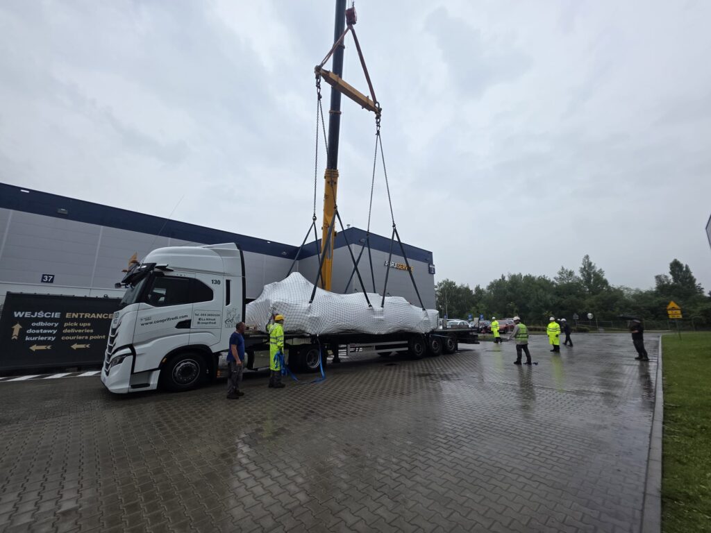 Rozładunek wielkogabarytowej maszyny przemysłowej z&nbsp;naczepy w&nbsp;ramach transportu międzynarodowego